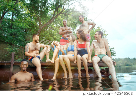 Enjoying river party with friends. Group of beautiful happy young people at the river together 42546568