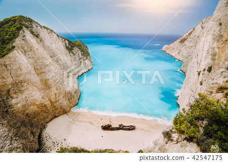 Shipwreck on Navagio beach. Azure turquoise sea water and paradise sandy beach in evening light Shipwreck on Navagio beach. Azure turquoise sea water and paradise sandy beach in evening light 42547175