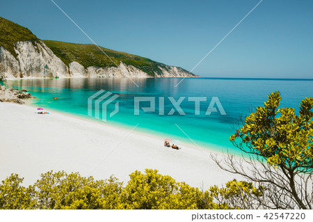 Amazing Fteri beach lagoon, Cephalonia Kefalonia, Greece. Tourists under umbrella relax near clear 42547220