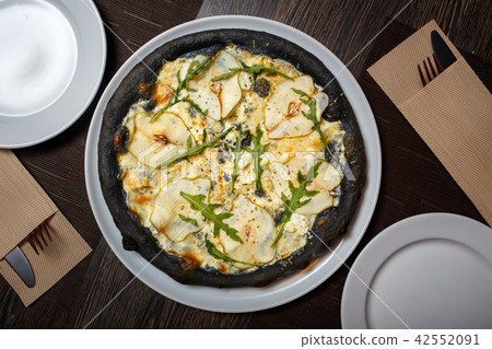 Black cheese pizza served on table in restaurant Black cheese pizza served on table in restaurant 42552091