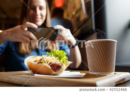 Young woman taking photo of her lunch in cafe Young woman taking photo of her lunch in cafe 42552466