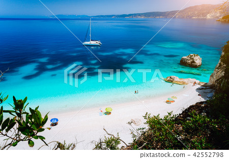 Fteri beach, Cephalonia Kefalonia, Greece. White catamaran yacht in clear blue sea water. Tourists 42552798