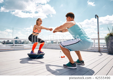 Man and woman are exercising together on rooftop 42555490