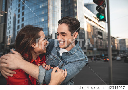 Pleased man and woman hugging on street 42555927