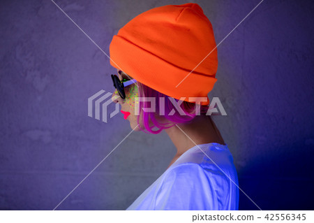 Young girl in hat with fluorescent paint 42556345