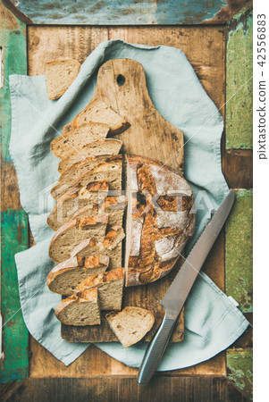 Flat-lay of sourdough wheat bread cut in slices in tray 42556883