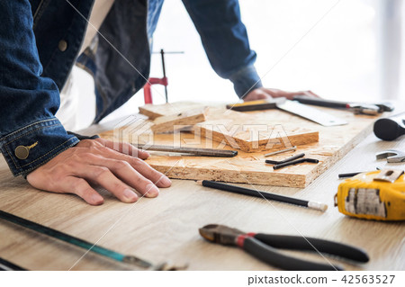Carpenter working carefully looking at the plans work in carpent Carpenter working carefully looking at the plans work in carpent 42563527