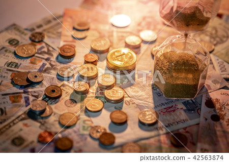 Hourglass and currency on table, Time Investment Hourglass and currency on table, Time Investment 42563874