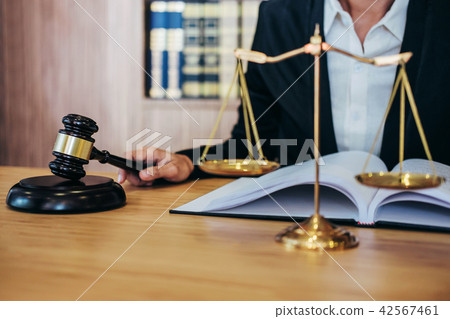 Gavel on wooden table and female Lawyer or Judge working with ag 42567461