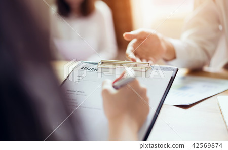 Young woman submit resume to employer to review. Young woman submit resume to employer to review. 42569874