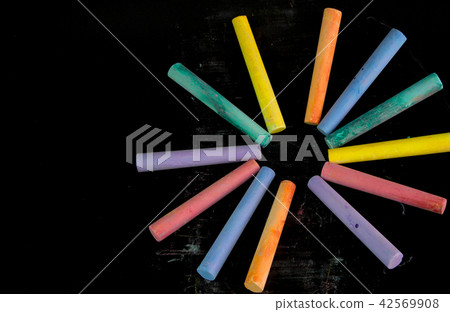Multi color chalks on black background 42569908