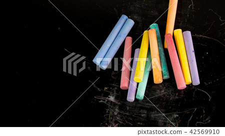Multi color chalks on black background 42569910