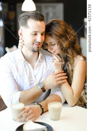 Young pretty woman hugging man and sitting at cafe. 42571138