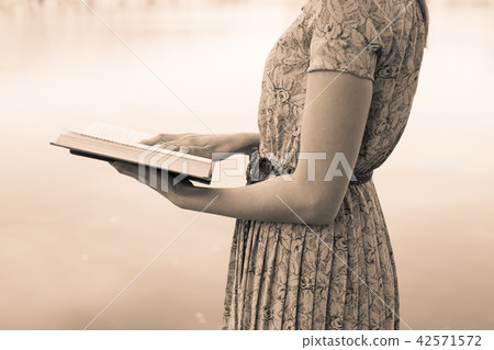 Young woman reading bible in natural park 42571572