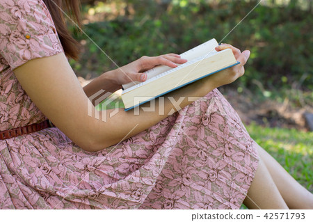 Young woman reading bible in natural park 42571793