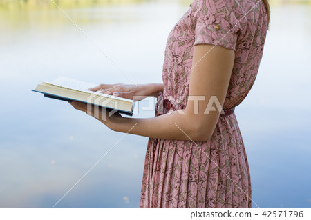 Young woman reading bible in natural park 42571796