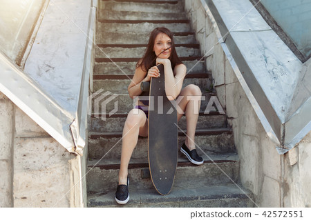 Beautiful young girl with a long board 42572551
