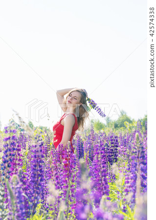 Girl with a flower on a field of lupines 42574338