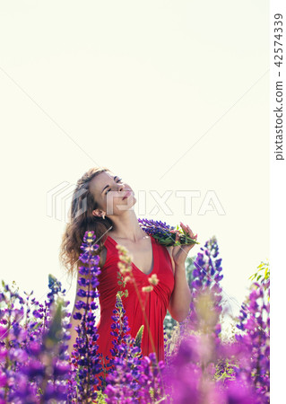 Portrait of a beautiful woman in a field of lupines 42574339