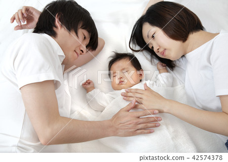 A young couple looking at a newborn baby and looking at it, a happy family image 42574378