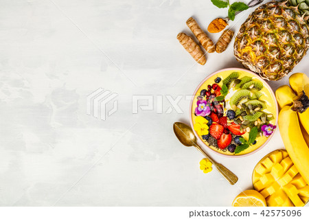 Mango banana pineapple turmeric smoothie bowl 42575096