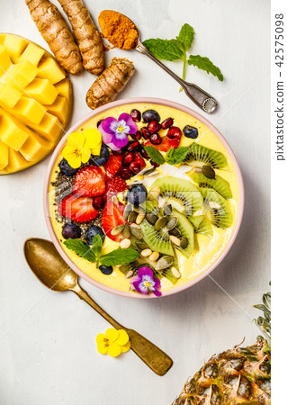 Mango banana pineapple turmeric smoothie bowl 42575098