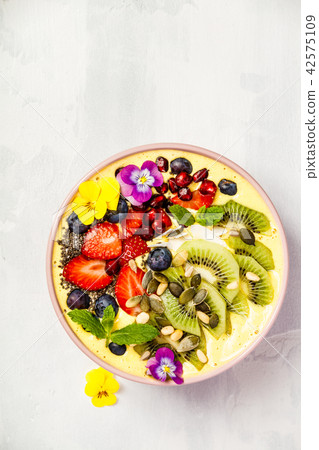 Mango banana pineapple turmeric smoothie bowl 42575109