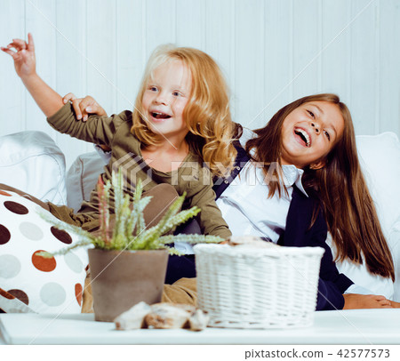 two cute girl sisters at home interior playing, little happy smi 42577573