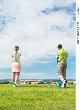 Young woman practicing the correct move during golf class 42578215