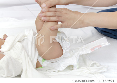 Procedure for replacing the newborn diaper 3 - lay a new diaper under the buttocks Procedure for replacing the newborn diaper 3 - lay a new diaper under the buttocks 42578694