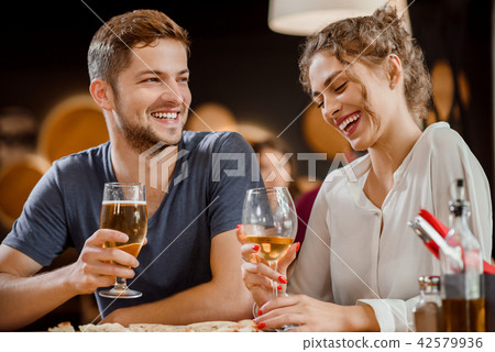 Beautiful couple holding glasses of white wine and beer in restaurant. Beautiful couple holding glasses of white wine and beer in restaurant. 42579936