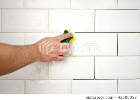 finishing the tiling of the kitchen with white til 42580059