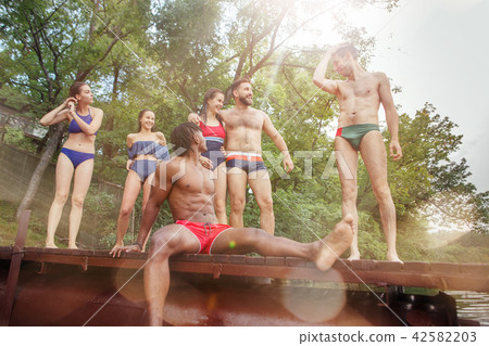 Enjoying river party with friends. Group of beautiful happy young people at the river together Enjoying river party with friends. Group of beautiful happy young people at the river together 42582203