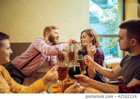 people, leisure, friendship and communication concept - happy friends drinking beer, talking and people, leisure, friendship and communication concept - happy friends drinking beer, talking and 42582224