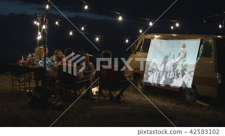 Friends watching movie in campsite 42583102
