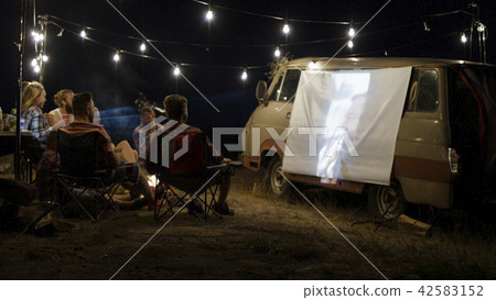 Friends watching movie in campsite 42583152