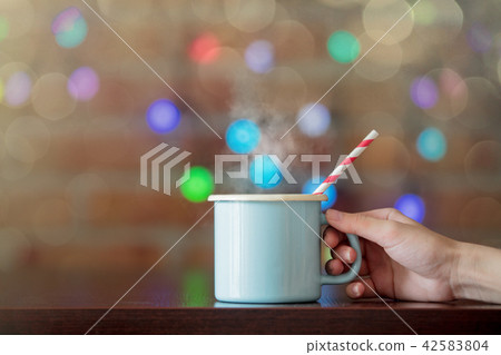Female hand holding a hot cup of coffee Female hand holding a hot cup of coffee 42583804