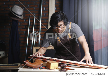 Asian Carpenter Working in Woodworking Workshop Asian Carpenter Working in Woodworking Workshop 42586681