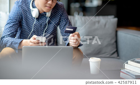 Asian man using credit card for online shopping 42587911
