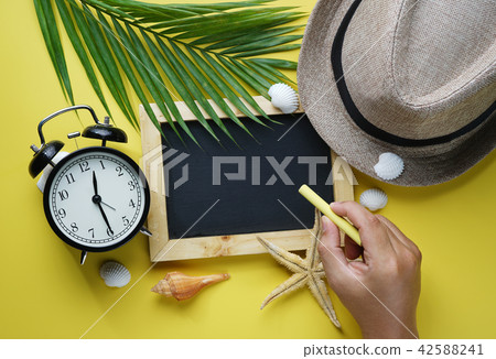 Hand Holding Yellow Chalk and Blackboard 42588241
