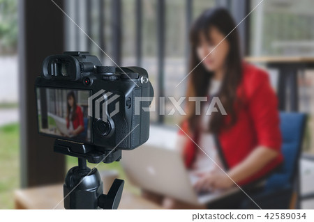 vlogger using  laptop  sharing her content making  42589034