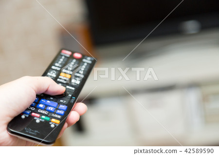 A woman turning on the TV 42589590