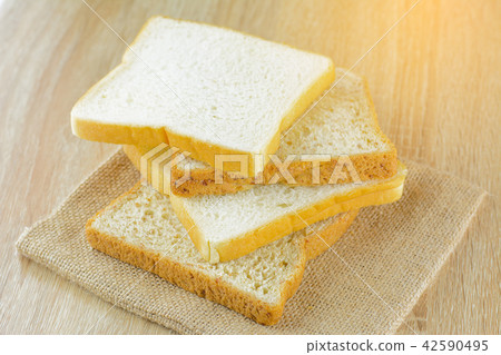 Sliced white and whole wheat bread on wood table. Sliced white and whole wheat bread on wood table. 42590495