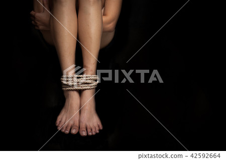 Feet of a kidnapped victim woman tied up with rope Feet of a kidnapped victim woman tied up with rope 42592664
