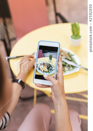 Woman making photo of her salad standing near cactus 42592850