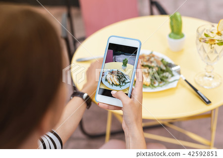 Modern blogger making photo of her summer salad in restaurant 42592851