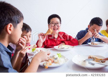 boy smiling while having lunch with friends  42593283