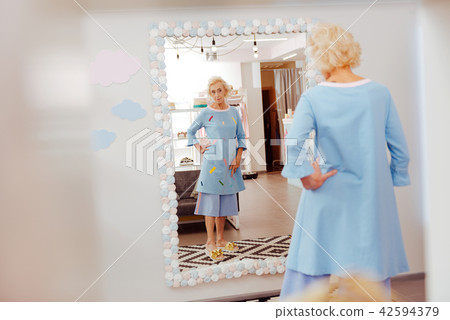 Blonde-haired retired woman trying blue costume on Blonde-haired retired woman trying blue costume on 42594379