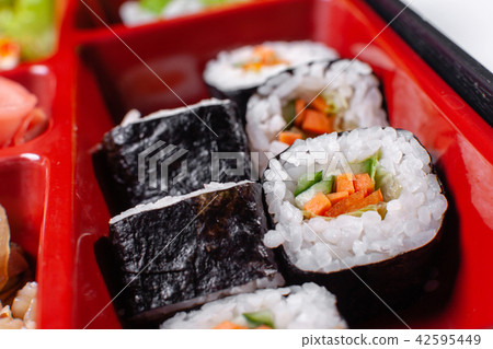 Fresh food portion in japanese bento box with salad, main course. Sushi roll with vegetables 42595449