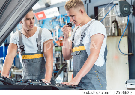 Experienced auto mechanic checking the parts of a car 42596620